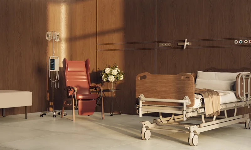 Care Pflegesessel in Rot neben einem Pflegebett